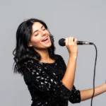 brunette woman singing to microphone