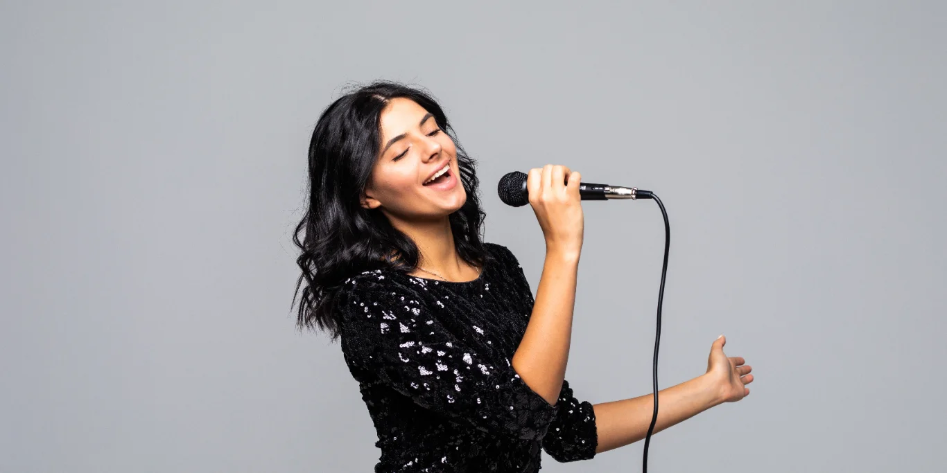 brunette woman singing to microphone